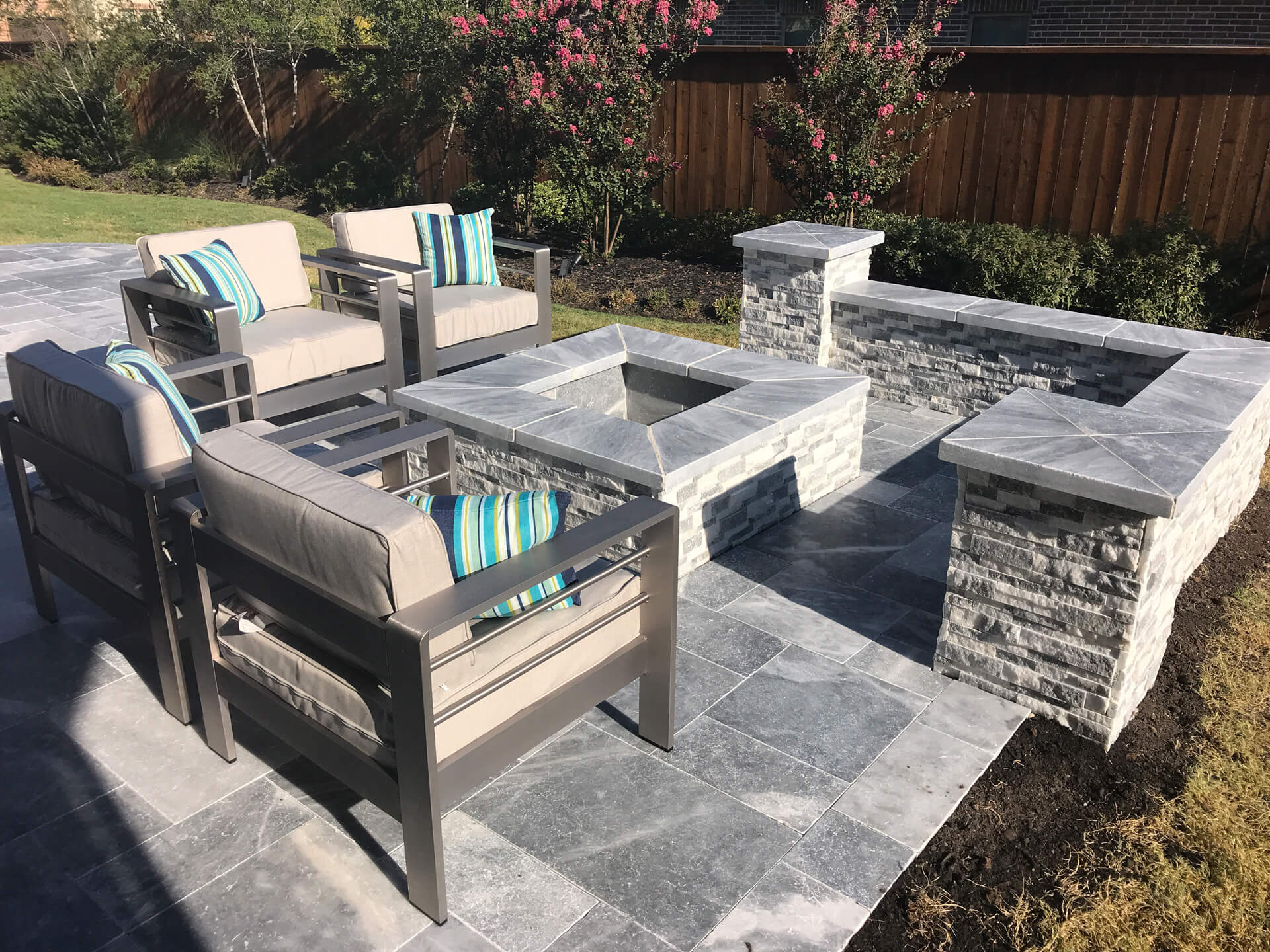 Square fire pit built into a deck with a square seating area behind.